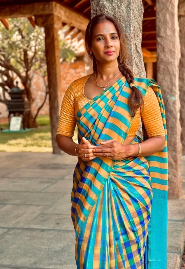 Arthi wearing an intricate wine and gold Kanchipuram silk saree